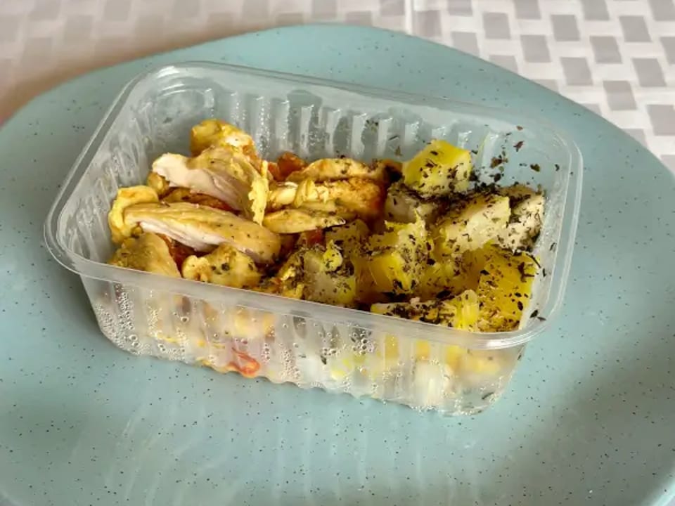 Frango em tiras com tomate picadinho e mandioca temperada.
